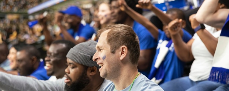 Two friends in a stadium crowd cheering their team